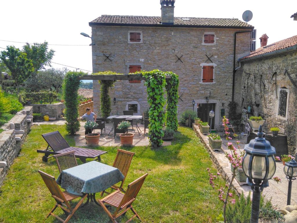 La terrazza esterna di Al Merlo Olivo, con pergola e tavoli tra le pietre a vista della casa